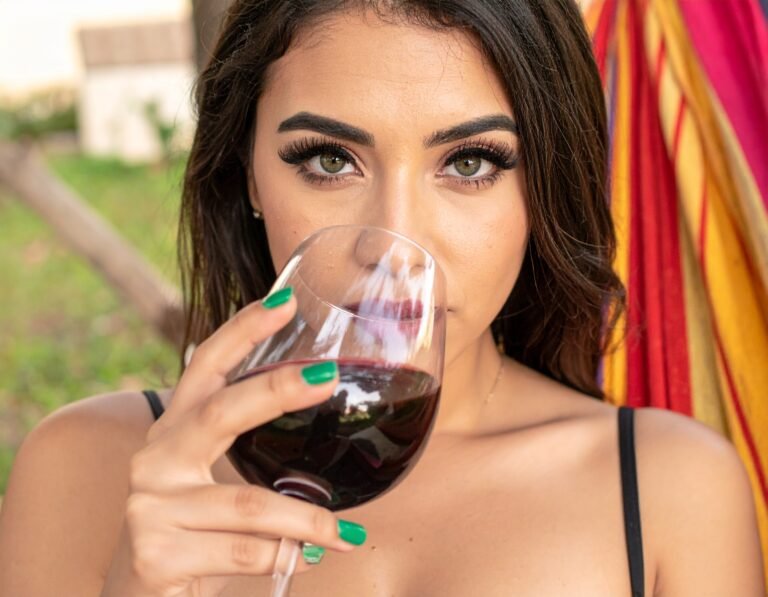 chica tomando vino en una hamaca