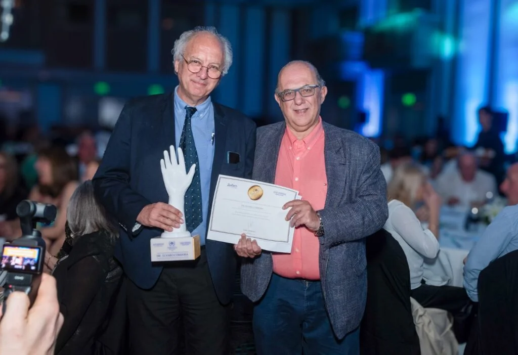 Dos científicos posan con la estatuilla y el diploma del Reconocimiento a la Ciencia y la Salud del Uruguay en la gala de Montevideo